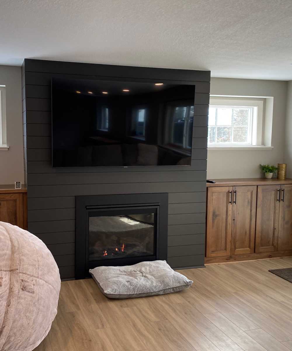 finished basement with light wood floors and electric fireplace - South Metro Custom Remodeling custom basement remodel