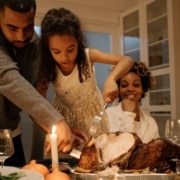 family carving turkey during holiday season - South Metro Custom Remodeling budget friendly basement ideas