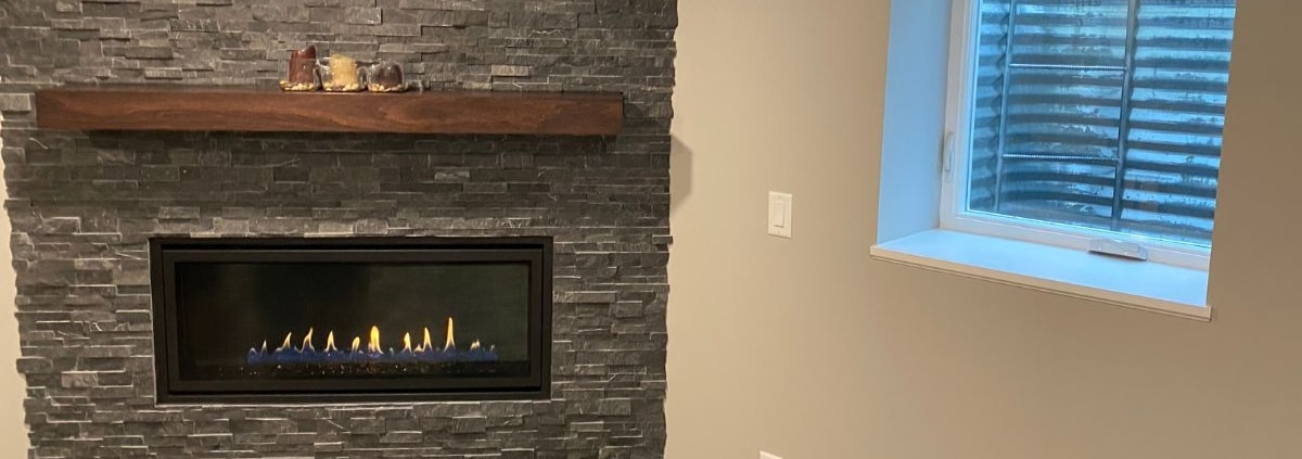 finished basement with stone fireplace and electric insert - South Metro Custom Remodeling basement contractor Edina MN