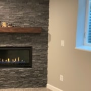 finished basement with stone fireplace and electric insert - South Metro Custom Remodeling basement contractor Edina MN