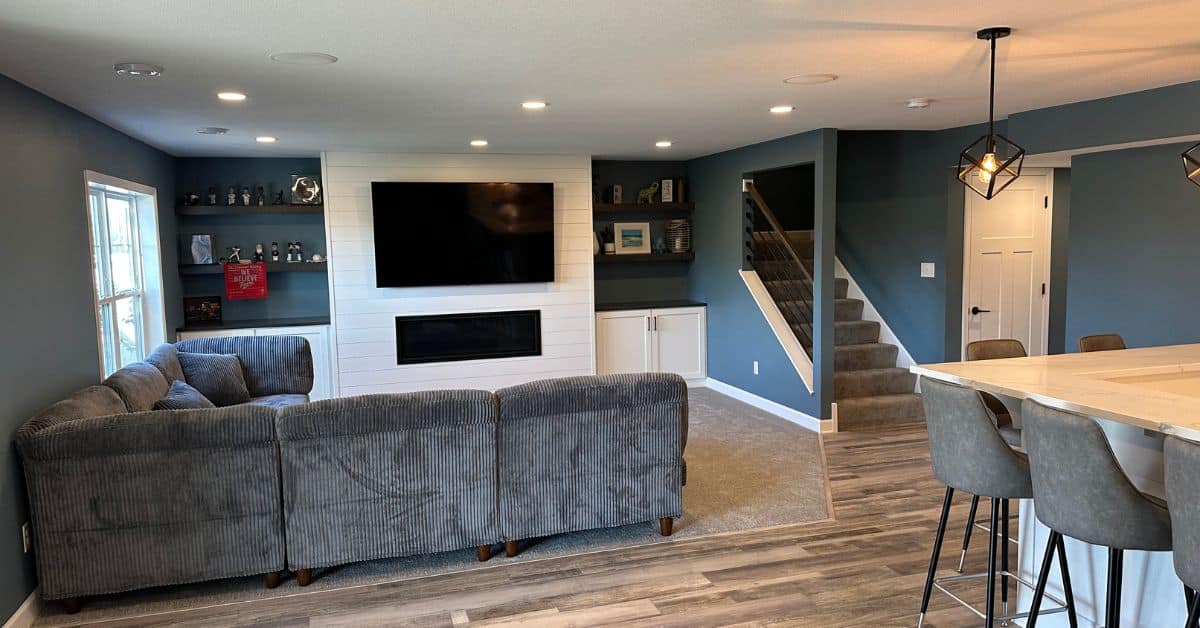 finished basement with large couch and electric fireplace - South Metro Custom Remodeling full basement remodel