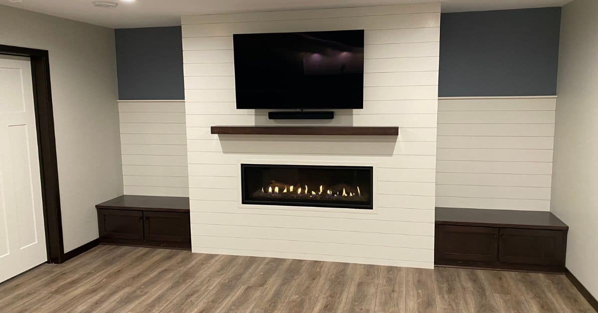 finished basement with white shiplap faced fireplace and mantle - South Metro Custom Remodeling basement contractor