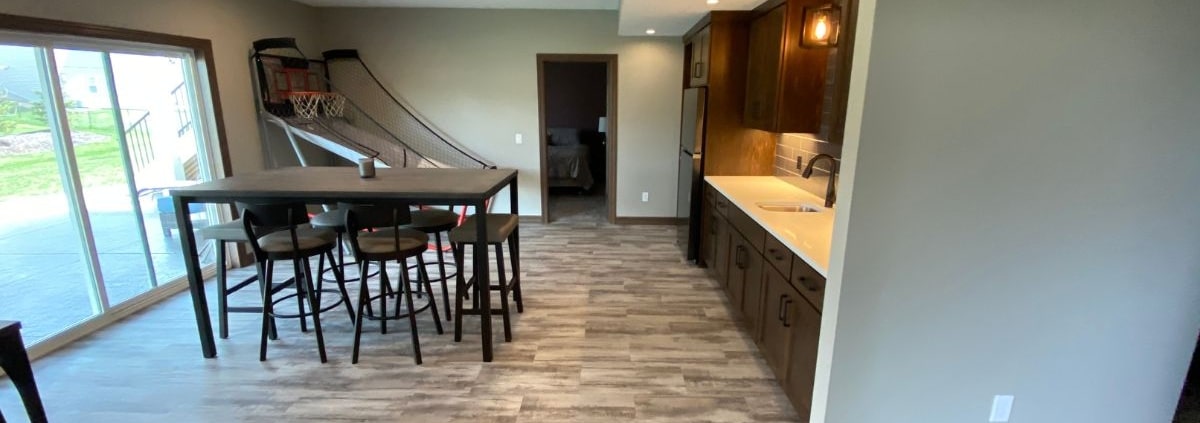 finished basement with basketball game and dining table - South Metro Custom Remodeling basement contractor