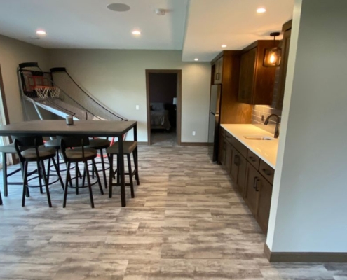 finished basement with basketball game and dining table - South Metro Custom Remodeling basement contractor