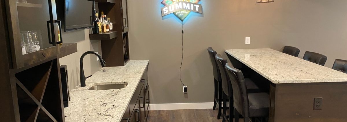 finished basement with a full kitchen and lit bar sign - South Metro Custom Remodeling basement contractor