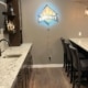 finished basement with a full kitchen and lit bar sign - South Metro Custom Remodeling basement contractor