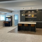 finished basement with arcade game and bar stools - South Metro Custom Remodeling unfinished basement