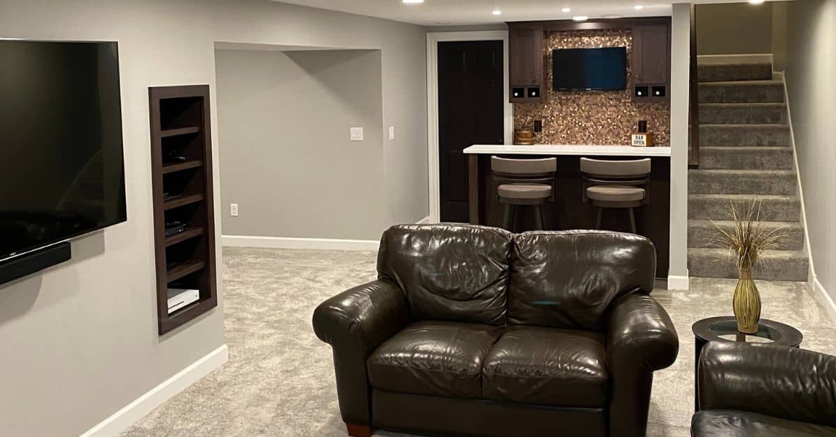 finished basement with grey carpet and brown leather couches - South Metro Custom Remodeling custom basement remodeling