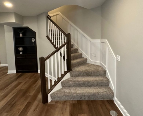 finished basement with carpeted stairs and dark wood floors - South Metro Custom Remodeling custom basement remodeling