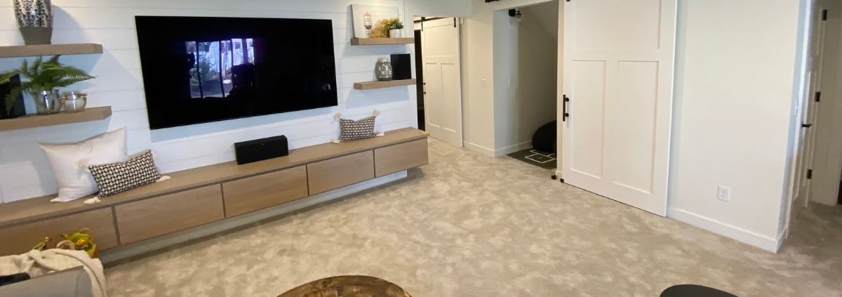 finished basement with custom cabinetry and wall mounted TV - South Metro Custom Remodeling custom basement remodeling