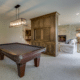 A billiard table in a cozy room featuring a couch and television, enhancing the space to increase home value with basement remodel.